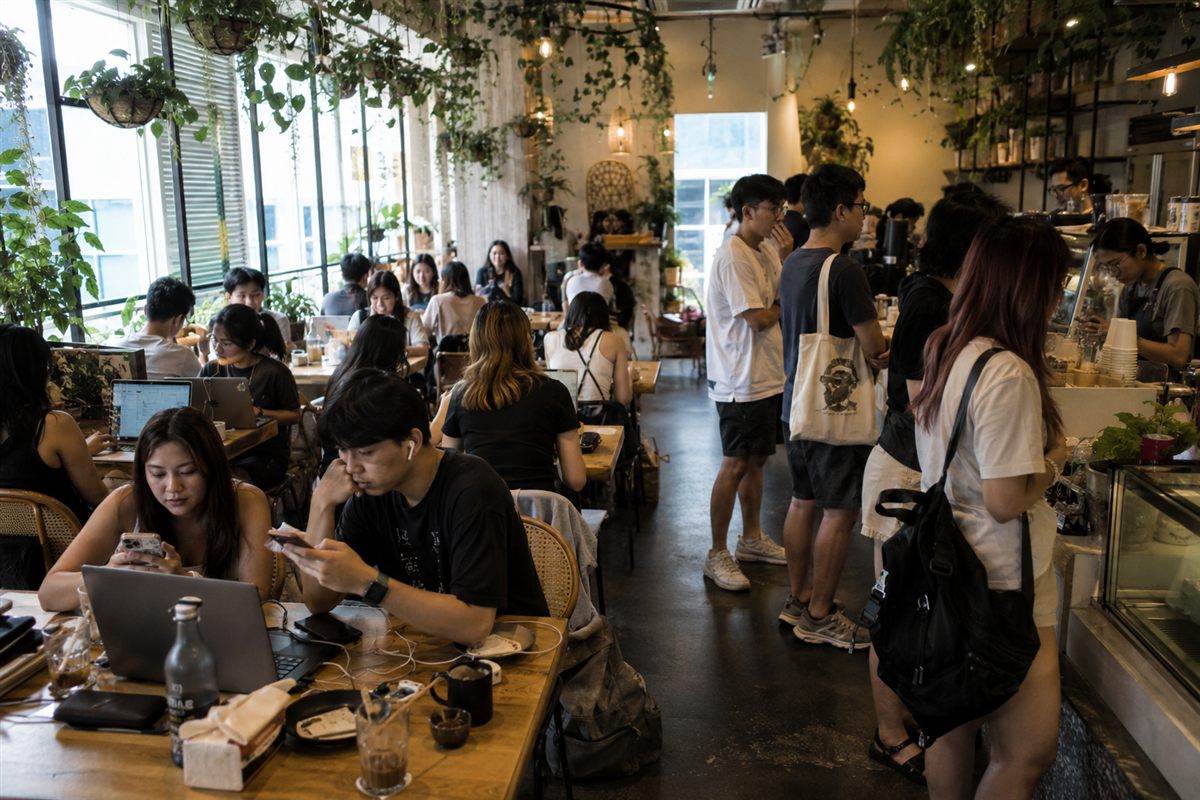 A Singapore café manager handling WhatsApp reservation enquiries during service