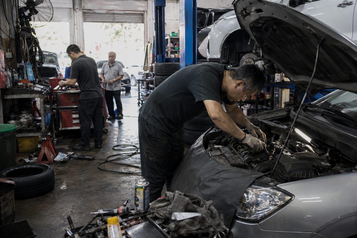 A Singapore car workshop advisor checking a WhatsApp servicing enquiry on a phone