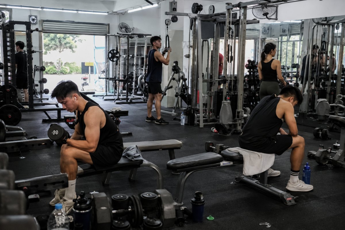 A modern gym floor with members using smart equipment and wearable fitness trackers