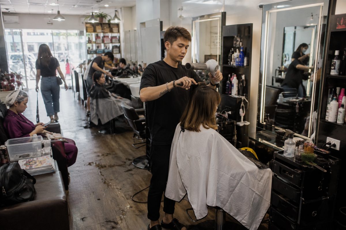 A Singapore salon receptionist managing WhatsApp appointment bookings on a phone