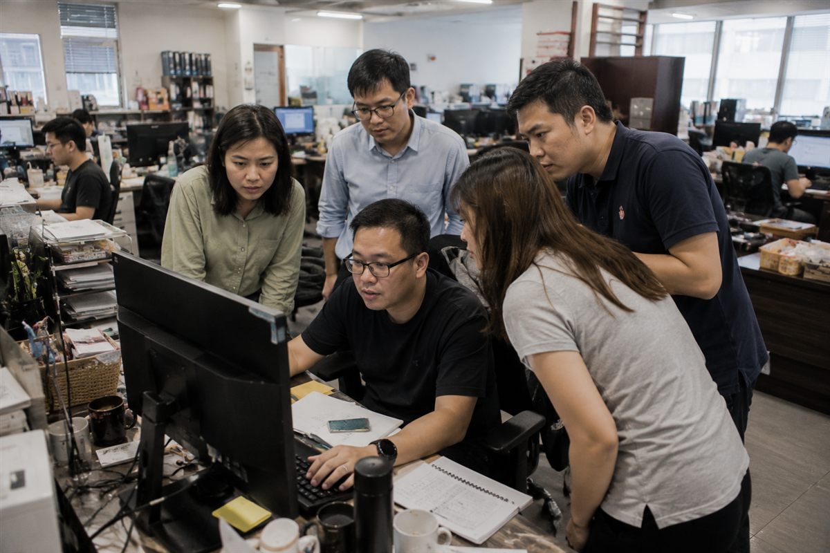A Singapore SME team using generative AI tools on laptops in a small office