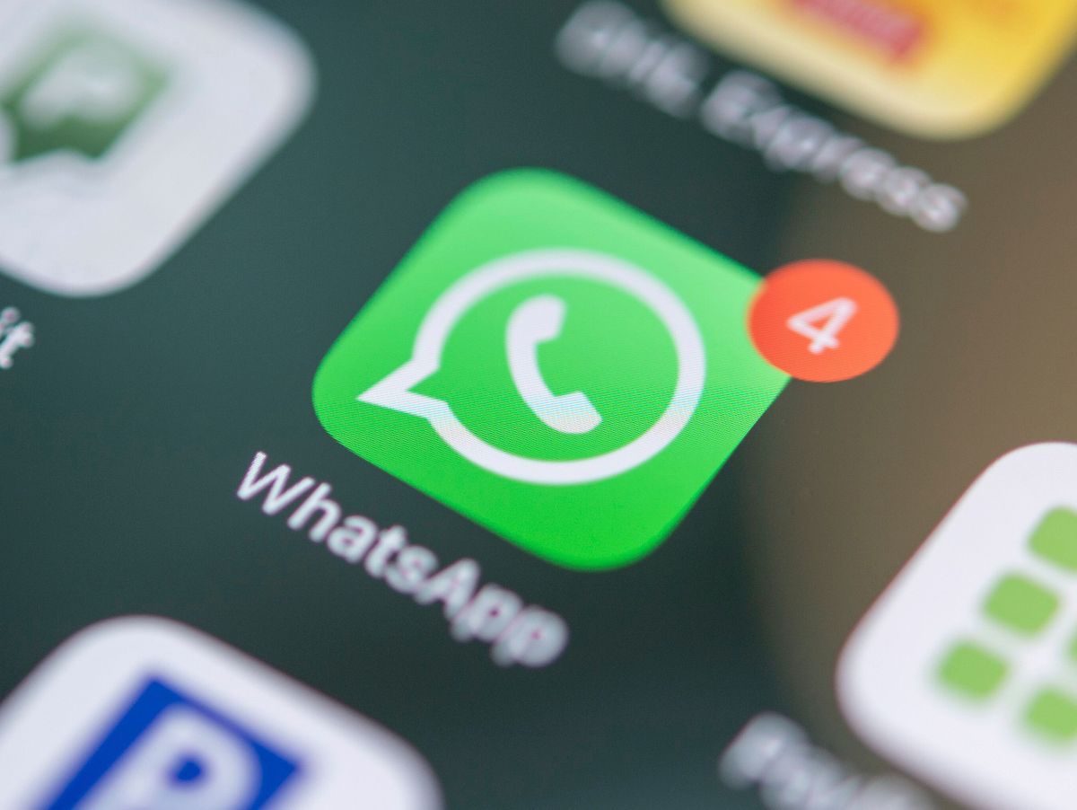 A Singapore small-business owner replying to customer enquiries in WhatsApp Business on a phone